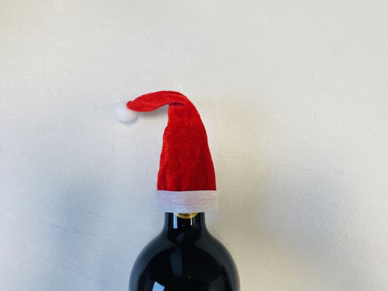 Weinflasche mit kleiner roter Weihnachtsmütze