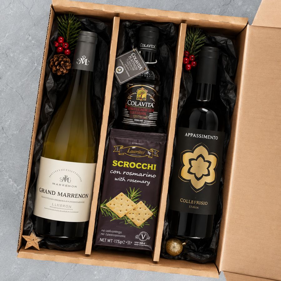 Wein-Geschenkpaket: Geöffnete 3er-Box mit Weißwein, Olivenöl, Scrocchi mit Rosmarin und Appassimento-Rotwein, dekoriert mit Tannenzweigen